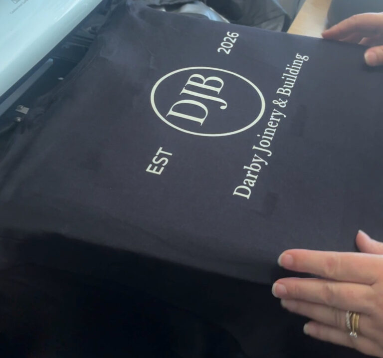 Business & Organisation Printing 12 Black tee with cream company logo being pressed